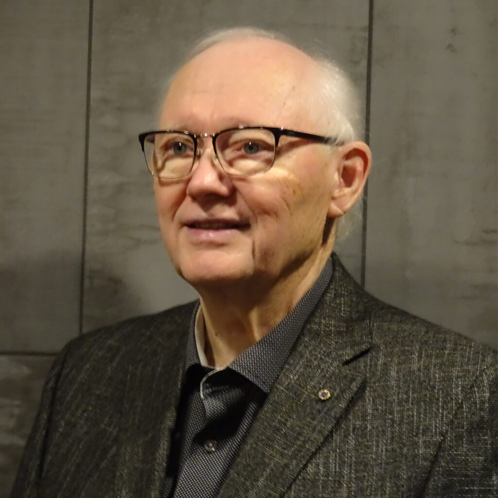 Dennis Souder Man in black suit jacket and shirt with glasses - Dennis Souder.
