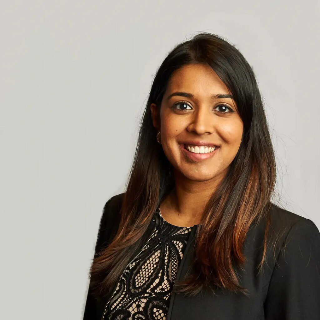 Pooja Jain Woman wearing a black shirt and smiling - Pooja Jain.